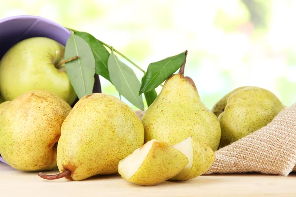 Pears in bucket on burlap on wooden table on nature background — Stock Photo, Image