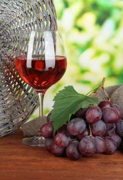 Rijp heerlijke druiven met glas wijn op tafel op lichte achtergrond — Stockfoto