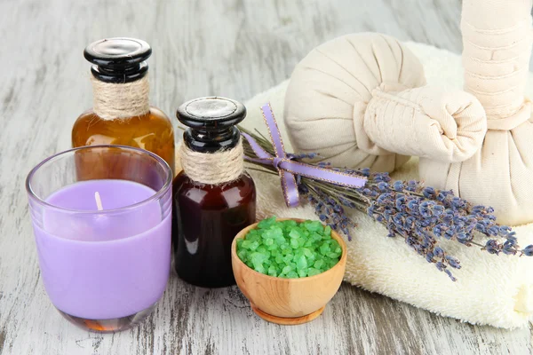 Stillleben mit Lavendelkerze, Seife, Massagekugeln, Flaschen, Seife und frischem Lavendel, auf Holzgrund — Stockfoto