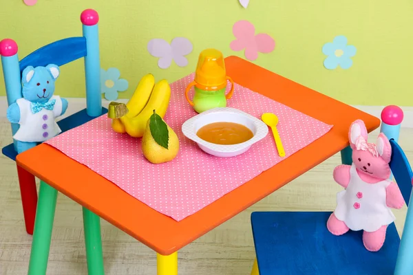 Smakelijke baby vruchtenmoes en Babyfles op tafel op kamer — Stockfoto