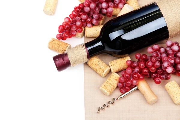 Bottles of wine, grapes and corks, isolated on white — Stock Photo, Image