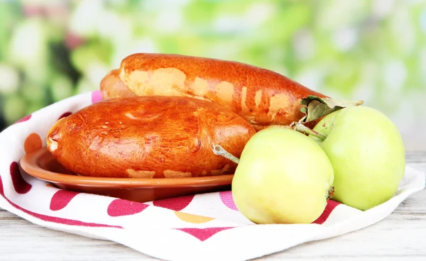 Fresh baked pasties with fruit jam, on wooden table, on bright background — Stock Photo, Image