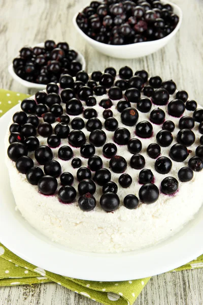 Tarta de queso con bayas frescas en plato blanco en primer plano de mesa de madera — Foto de Stock