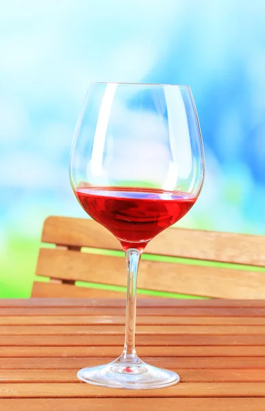 Glazen wijn op houten tafel op aard achtergrond — Stockfoto