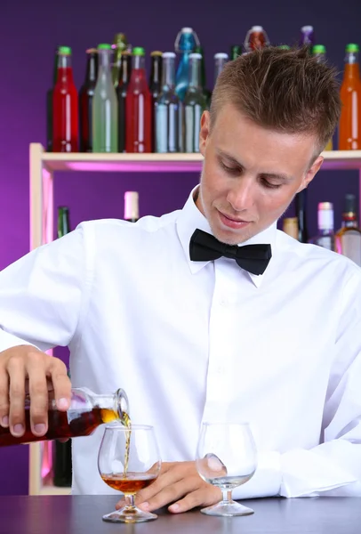 Bartender is pouring cognac into glass — Stock Photo, Image