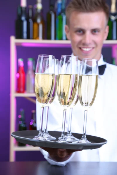 Bartender håller bricka med champagneglas — Stockfoto