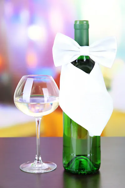 White bow tie on wine bottle on bright background — Stock Photo, Image