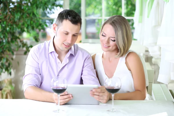 Casal jovem tirando foto com tablet no restaurante — Fotografia de Stock