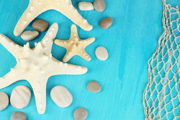 White starfishes on blue wooden table close-up — Stock Photo, Image