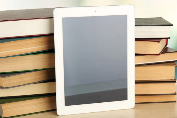 Tablet e livros sobre fundo claro — Fotografia de Stock