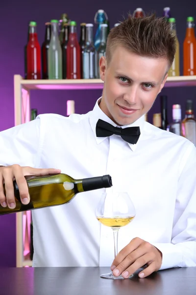 Bartender is pouring white wine into glass — Stock Photo, Image