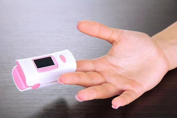 Pulse oximeter used to measure pulse rate and oxygen levels, on wooden background — Stock Photo, Image