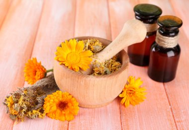 ilaç şişeleri ve ahşap zemin üzerine calendula çiçekler