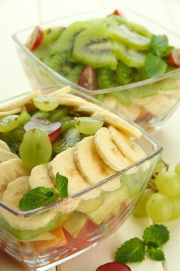 Beyaz tahta masada cam lezzetli meyve salatası kaseler