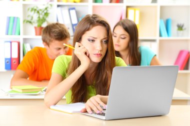 Kütüphanede oturan genç öğrenci grubu