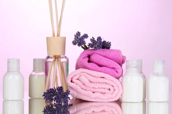 Flasche Lufterfrischer, Lavendel und Handtücher auf rosa Hintergrund — Stockfoto