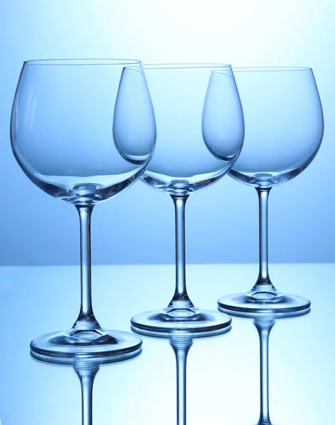 Verres à vin vides disposés sur fond bleu — Photo