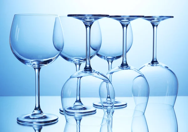 Mavi zemin üzerine düzenlenen boş şarap bardakları — Stok fotoğraf