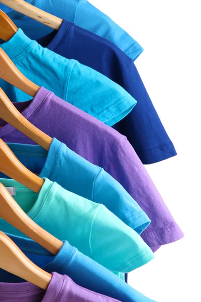 Lots of T-shirts on hangers isolated on white — Stock Photo, Image