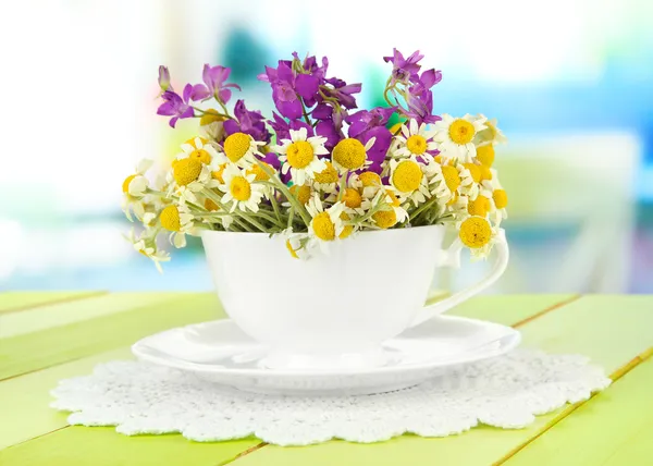 Μπουκέτο με λουλούδια χαμομήλι στο φλυτζάνι, σε φωτεινό φόντο — Φωτογραφία Αρχείου