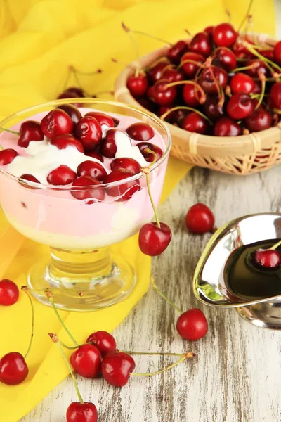 Вкусный вишневый десерт в стеклянной вазе на деревянном столе крупным планом — стоковое фото