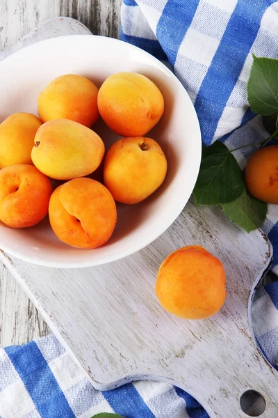 Abricots à bord pour couper sur serviette sur table en bois — Photo