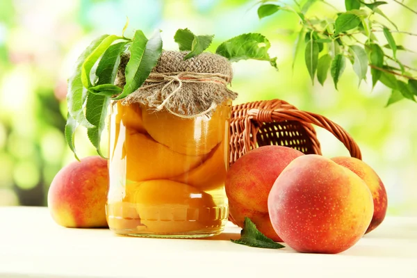 Dosenpfirsiche und frische Pfirsiche auf Holztisch, draußen — Stockfoto