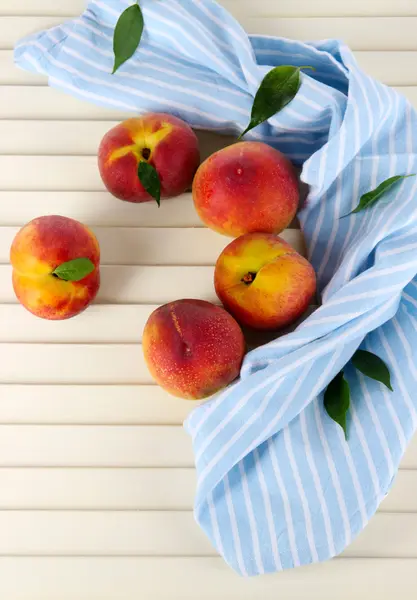 在木桌子上的餐巾纸上的桃子 — 图库照片