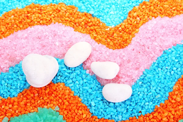 Pedras brancas em cristais coloridos de fundo de sal marinho — Fotografia de Stock