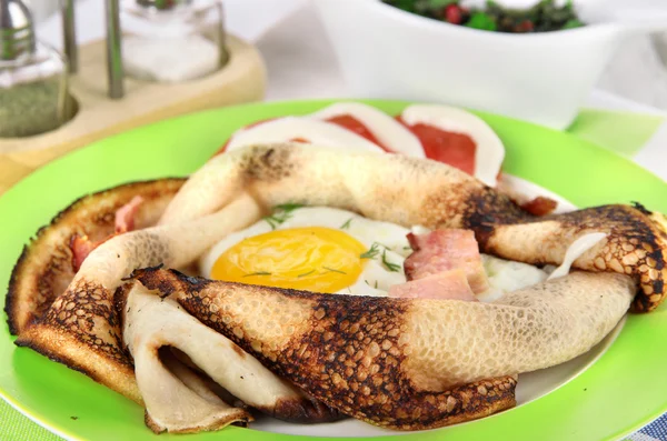 Huevos revueltos y tortitas en plato sobre servilleta sobre mesa de madera — Foto de Stock