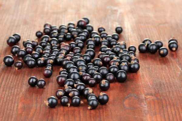 Färska svarta vinbär på trä bakgrund — Stockfoto