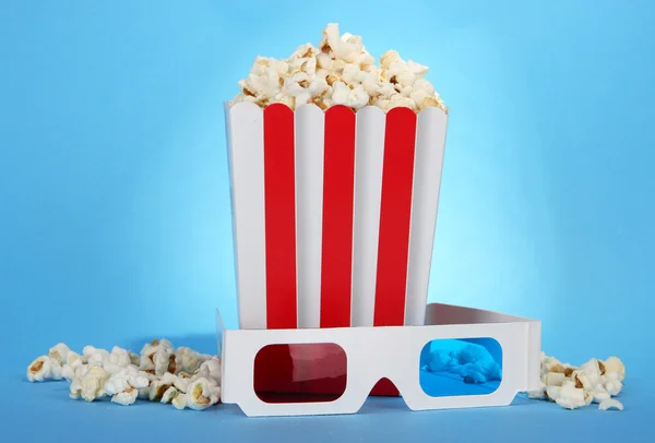 Popcorn a 3d brýle na modrém pozadí — Stock fotografie