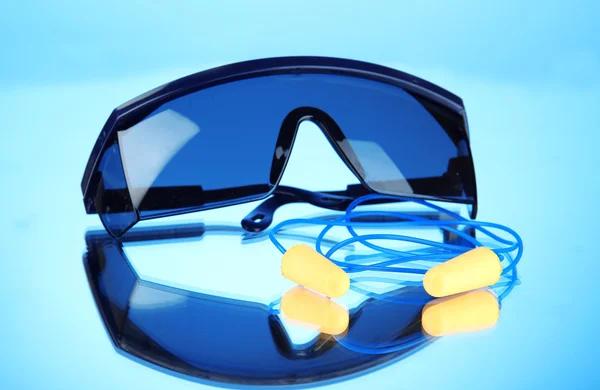Glasögon verktyg och öronproppar på blå bakgrund — Stockfoto