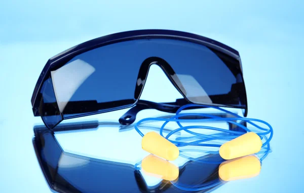 Brillenwerkzeuge und Ohrstöpsel auf blauem Hintergrund — Stockfoto