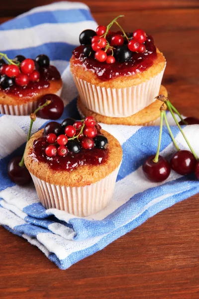 Tasty muffins with berries on wooden table — Stock Photo, Image