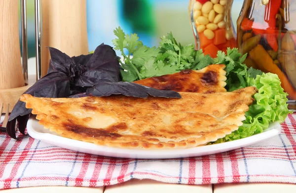 Chèques savoureux avec des herbes fraîches sur l'assiette, sur la table en bois, sur fond lumineux — Photo