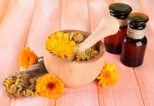 ilaç şişeleri ve ahşap zemin üzerine calendula çiçekler
