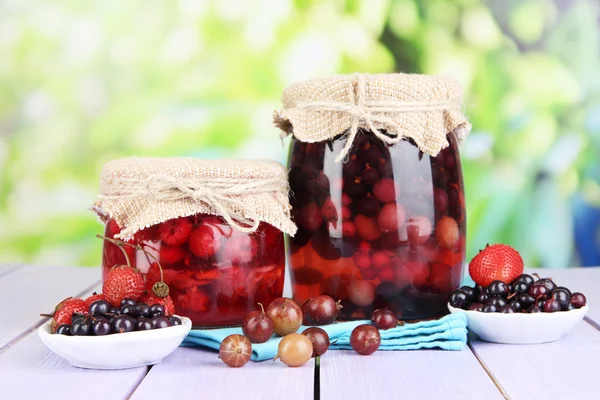 Marmellata di bacche fatta in casa su tavolo di legno su sfondo luminoso — Foto Stock