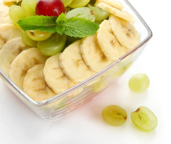 Smakelijke fruitsalade in glazen kom, geïsoleerd op wit — Stockfoto
