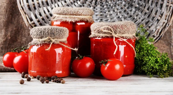 Tomates enlatados e frescos saborosos na mesa de madeira — Fotografia de Stock