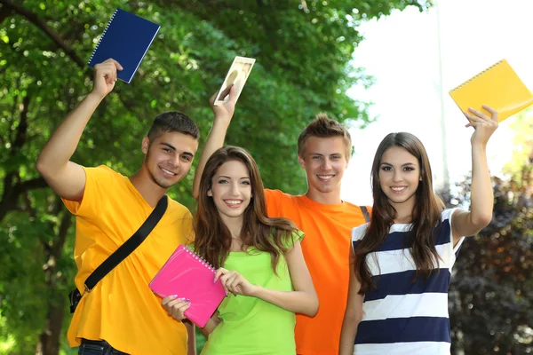 Happy group of young students standing in park — Stock Photo, Image