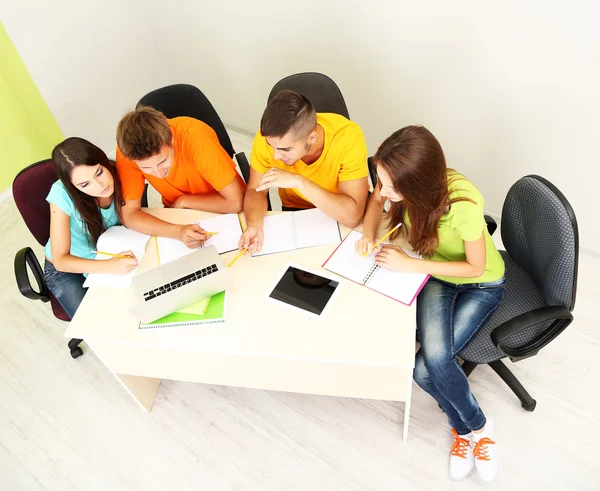 Grupo de jóvenes estudiantes sentados en la habitación — Foto de Stock