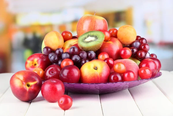 Sortimento de frutas suculentas na mesa de madeira, no fundo brilhante — Fotografia de Stock