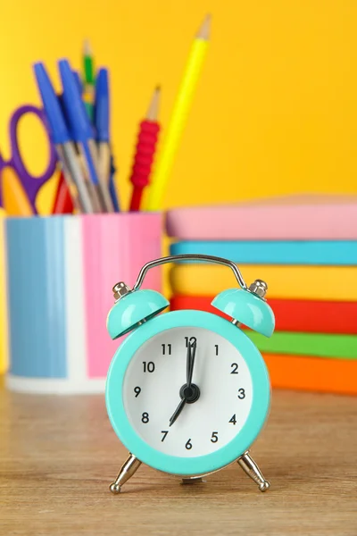 Blå väckarklocka på bordet på gul bakgrund — Stockfoto
