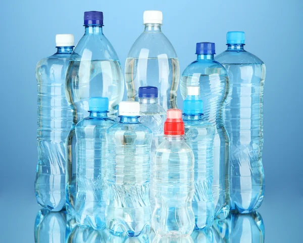 Bottles of water, on blue background — Stock fotografie