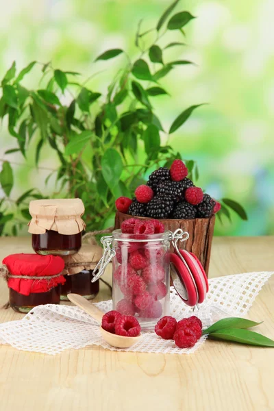 Ripe raspberries and blackberries on wooden table on natural background — Stock Photo, Image