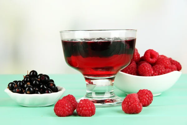 Gelee mit frischen Beeren auf grünem Holztisch — Stockfoto