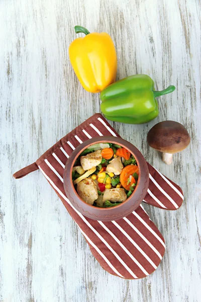 Vegetal misto assado com peito de frango em panela no potholder, no fundo de madeira — Fotografia de Stock