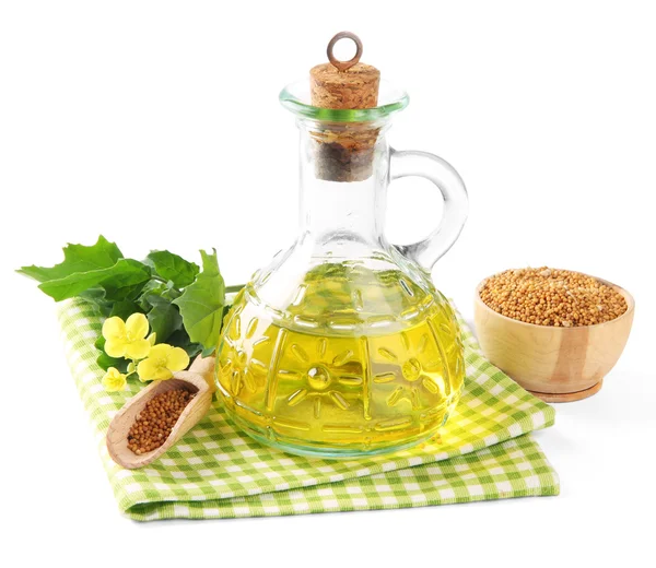 Vaso di olio di senape e semi con fiore di senape su sfondo di legno — Foto Stock