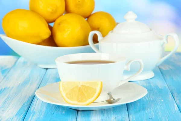 Tasse de thé au citron sur table sur fond bleu — Photo